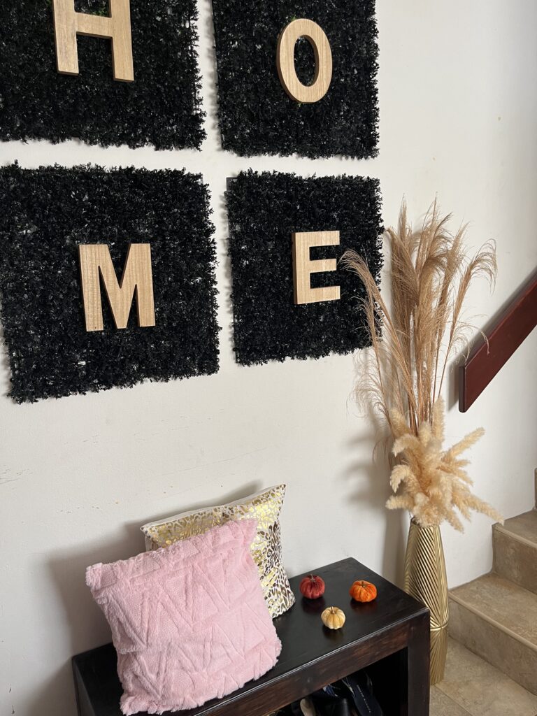  Pink cushion, mini pumpkins, and gold vase with pampas grass