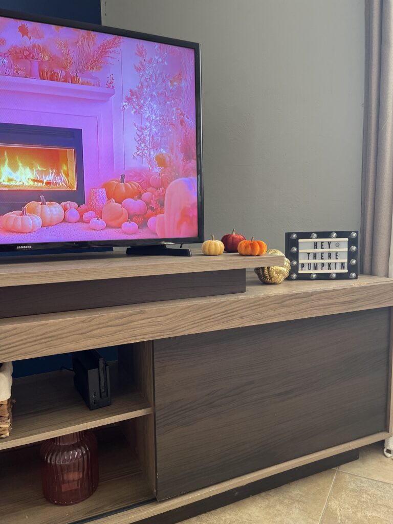 Fall living room decor with mini pumpkins and a Hey There Pumpkin sign